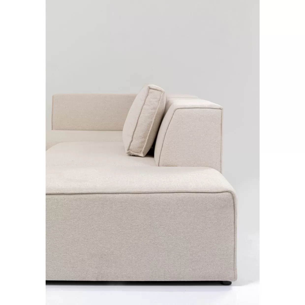 Divano angolare Infinity con poggiapiedi integrato in tessuto crema chiaro - Design moderno KARE